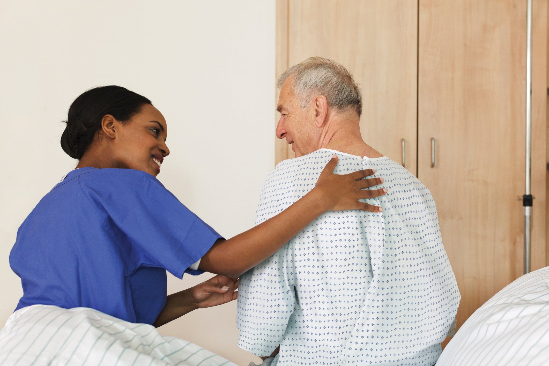 nurse-sitting-on-bed-with-patient