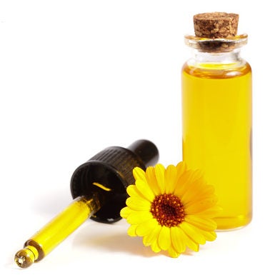 Marigold flower and small bottle of marigold/calendula oil. Marigold flower and small bottle of marigold/calendula oil.