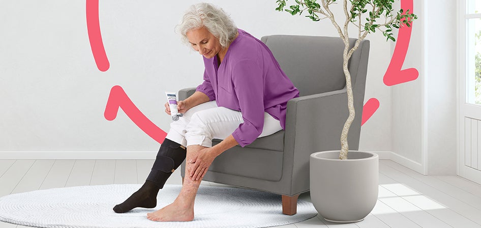 118147_Venous_Ulcers_banner_mobile Elderly woman sitting in chair, with COMPRECARES compression therapy product on one leg, applying moisturizer to other leg.