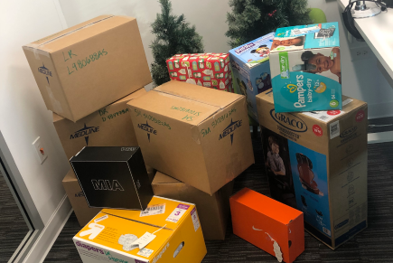 Collection of boxes in front of two small Christmas trees. Collection of boxes in front of two small Christmas trees.