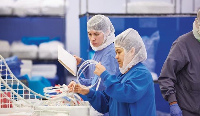 Two workers inspecting medical equipment. Two workers inspecting medical equipment.