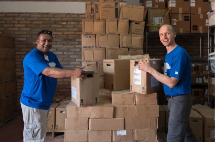 Two Medline employees stacking boxes inside a warehouse. Two Medline employees stacking boxes inside a warehouse.