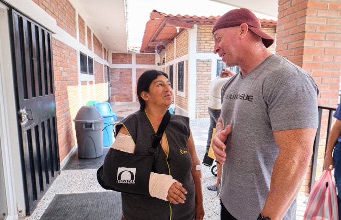 Medline employee talks to a patient with a bandaged arm. Medline employee talks to a patient with a bandaged arm.