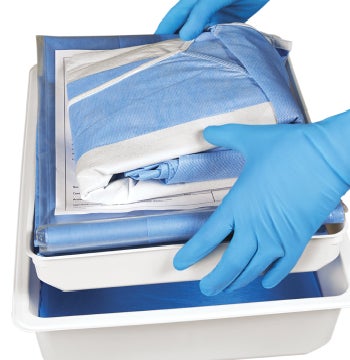 Gloved caregiver’s hands opening a central line insertion bundle Gloved caregiver's hands opening a central line insertion bundle
