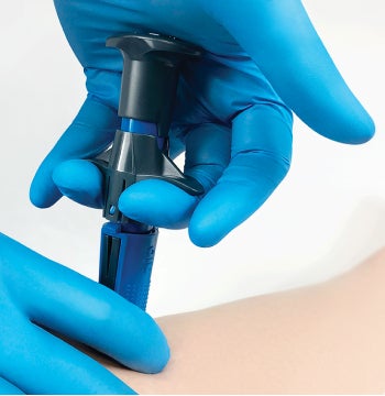 Gloved caregiver’s hands using the NIO intraosseous device to gain vascular access from the shinbone Gloved caregiver's hands using the NIO intraosseous device to gain vascular access from the shinbone