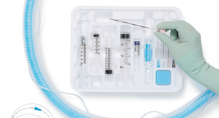 conversion-made-easy Custom anesthesia kit filled with supplies and gloved hand on top picking up glass tube with markings
