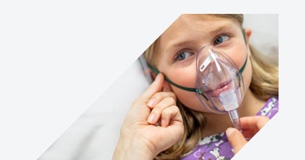 Yound girl in OxyMask™ Arrow-shaped close-up of caregiver hands adjusting an OxyMask™, oxygen mask on a young girl