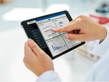 transition-1-min Close-up of caregiver scrolling through patient health information on a tablet