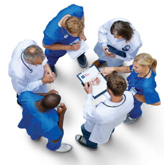 Six clinicians in scrubs standing in a circle reviewing paperwork on a clipboard